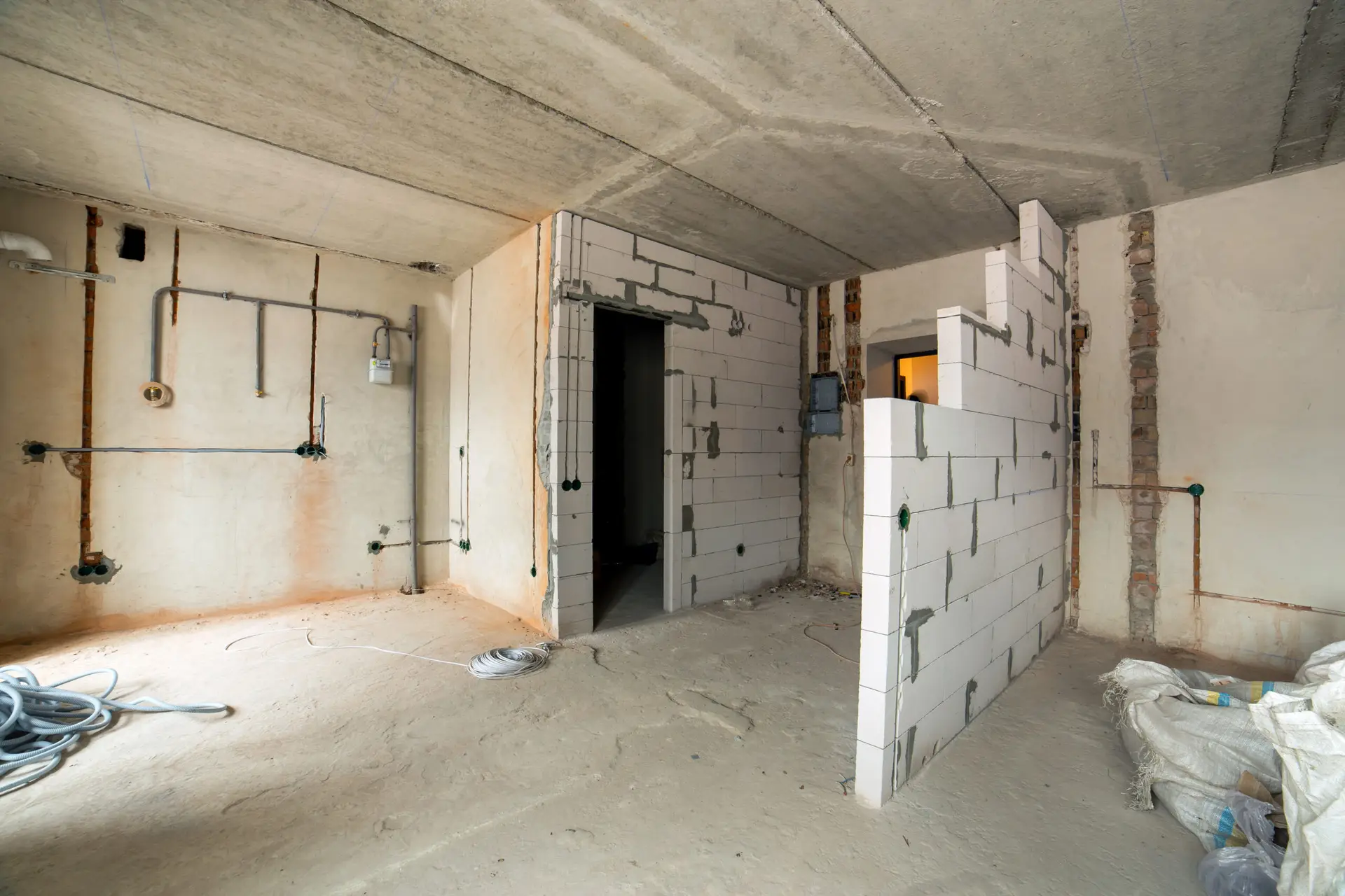 Interior of an apartment room with bare walls and ceiling under